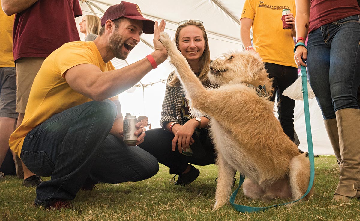 ASU Alumni giving a dog a high five