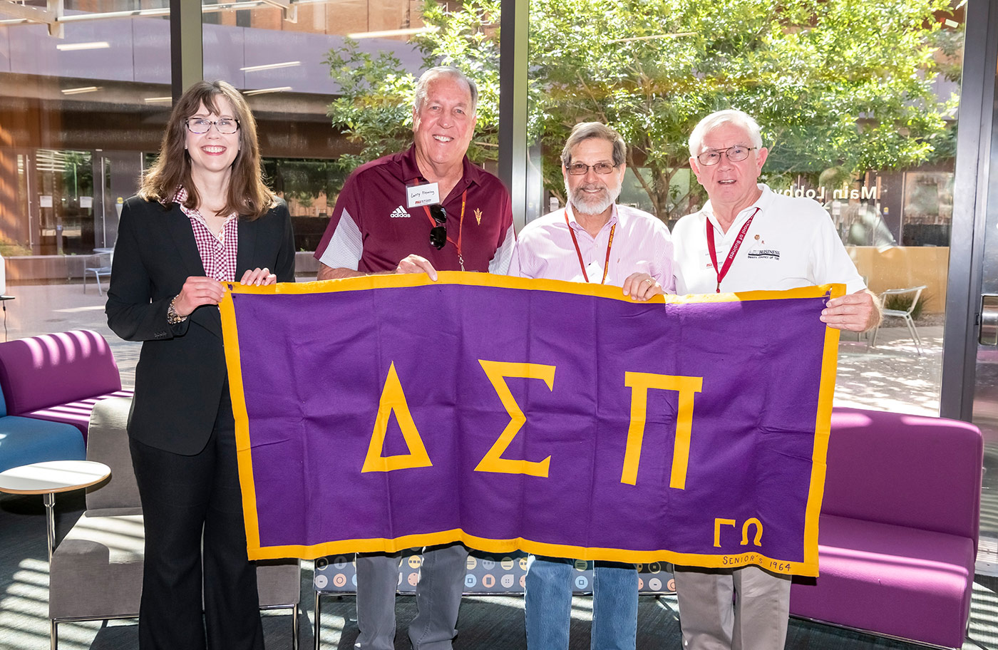 From left: Vice Dean Amy Ostrom and members of the Delta Sigma Pi business fraternity Larry Fleming (BS Business Administration ’72), Irwin Sheinbein (BS Business Administration ’72), and John Richardson (BS Business Administration ’72) hold the 1964 Delta Sigma Pi banner