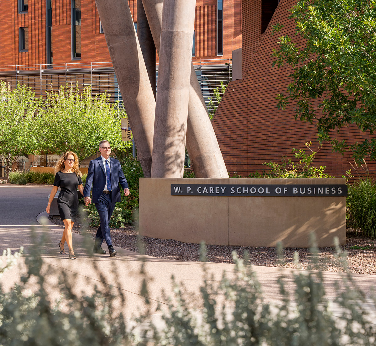 A landscape photograph of Ohad Kadan walking on the campus of W.P. Carey School of Business alongside his wife