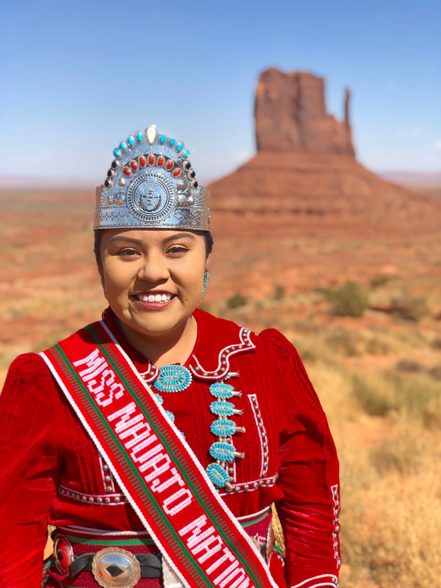 Shaandlin Parrish as Miss Navajo Nation in front of a natural monument in the desert.