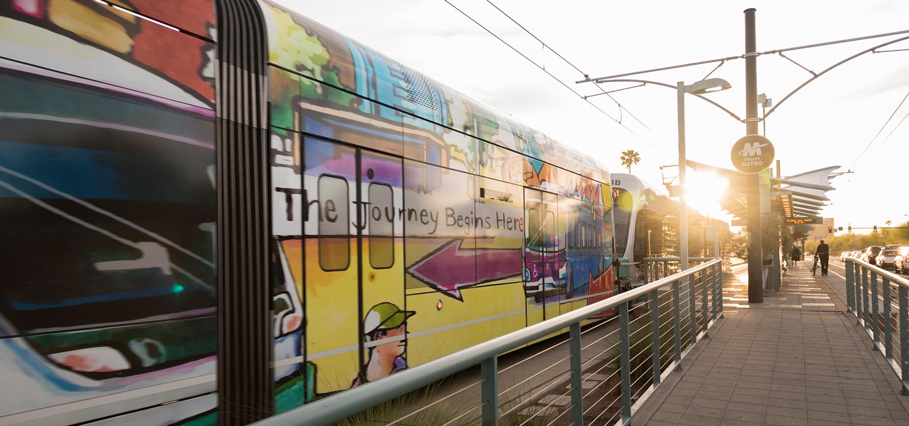 a rail transport covered with art is stopped at a station