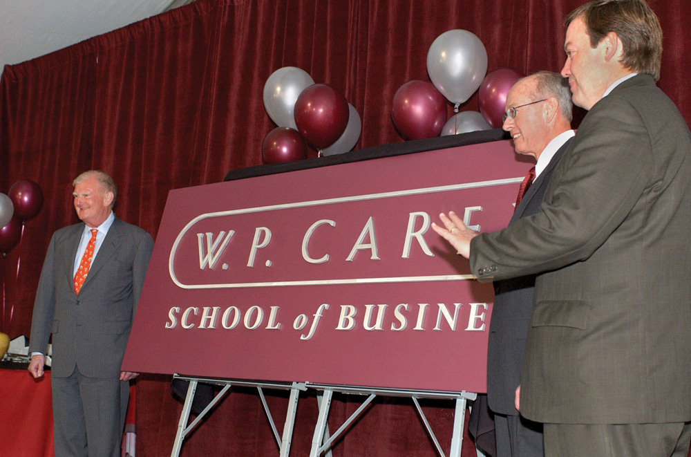 William Polk Carey, Larry Penley, and Michael Crow presenting the new logo for the W. P. Carey School of Business