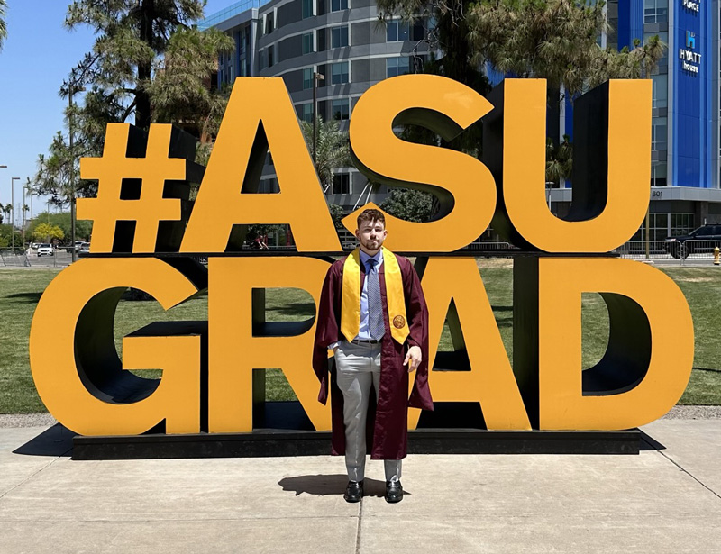 ASU graduate student with big graphic behind stating "#ASU GRAD"