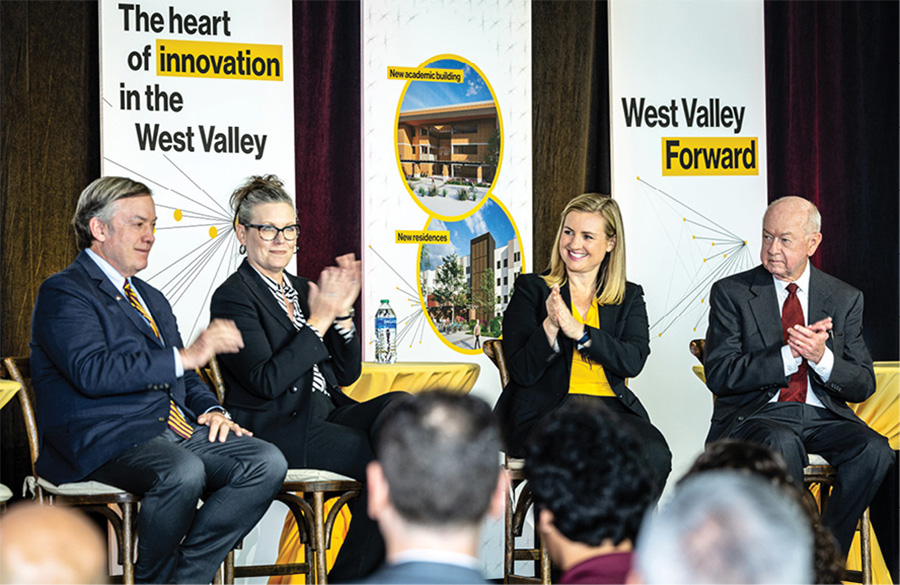 four people sitting down for a panel in front of an audience