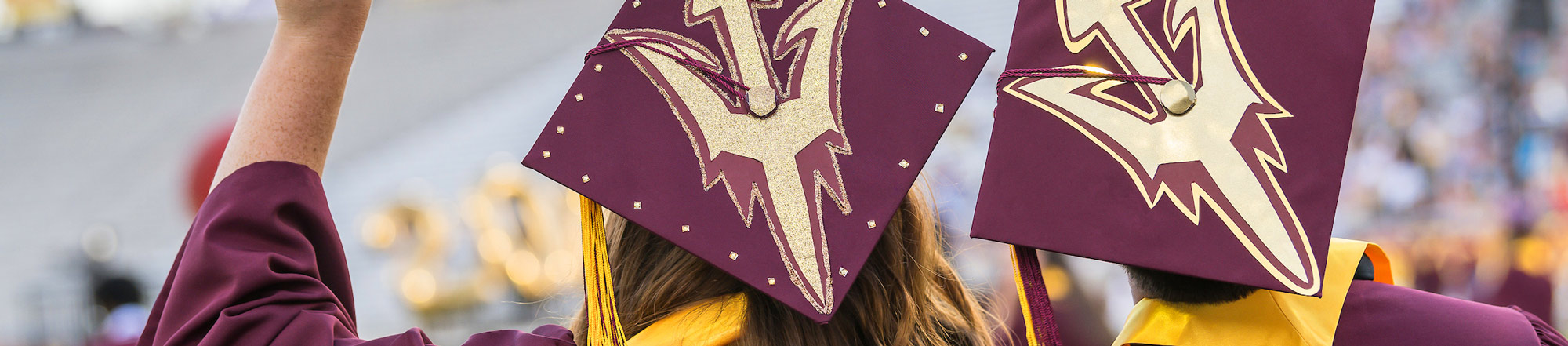 back of students graduation caps with ASU's logo