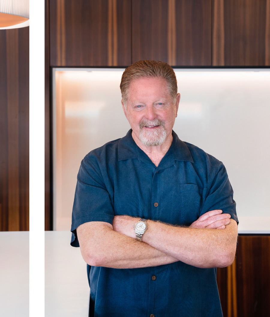 Bill Kent smiling in blue button up with arms crossed