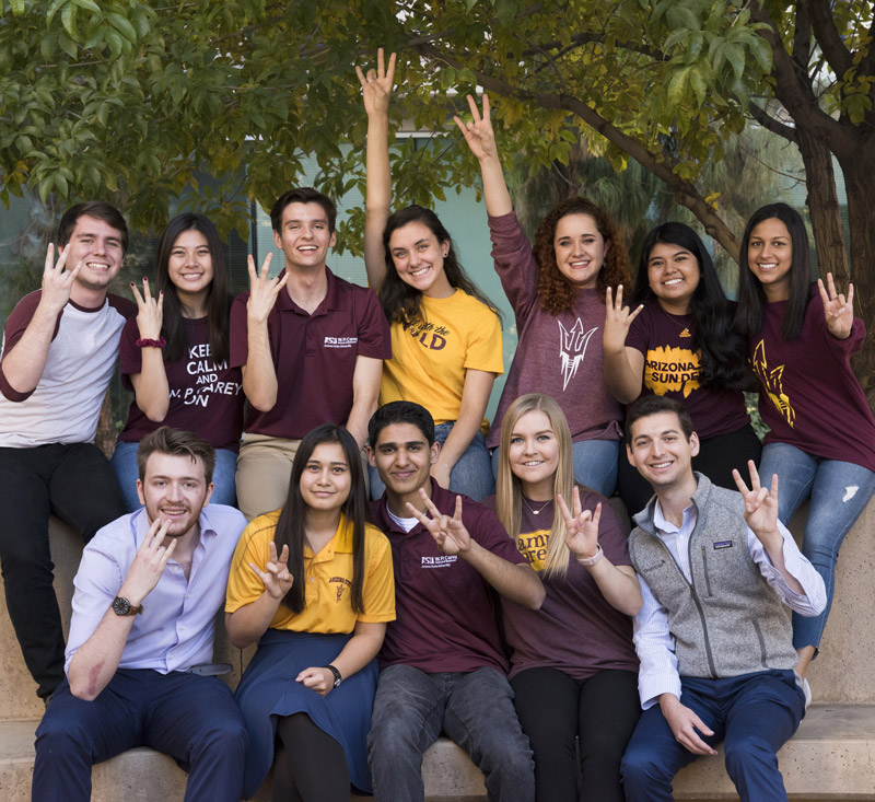 a group of ASU students using a hand symbol for a photo
