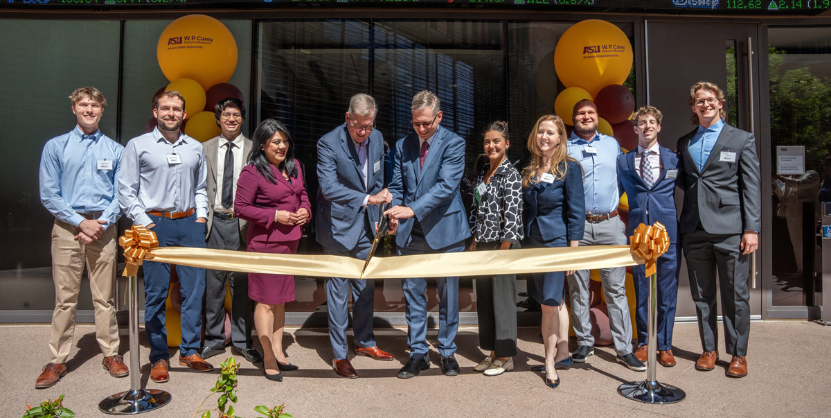 group of people gathered for a ribbon cutting ceremony 