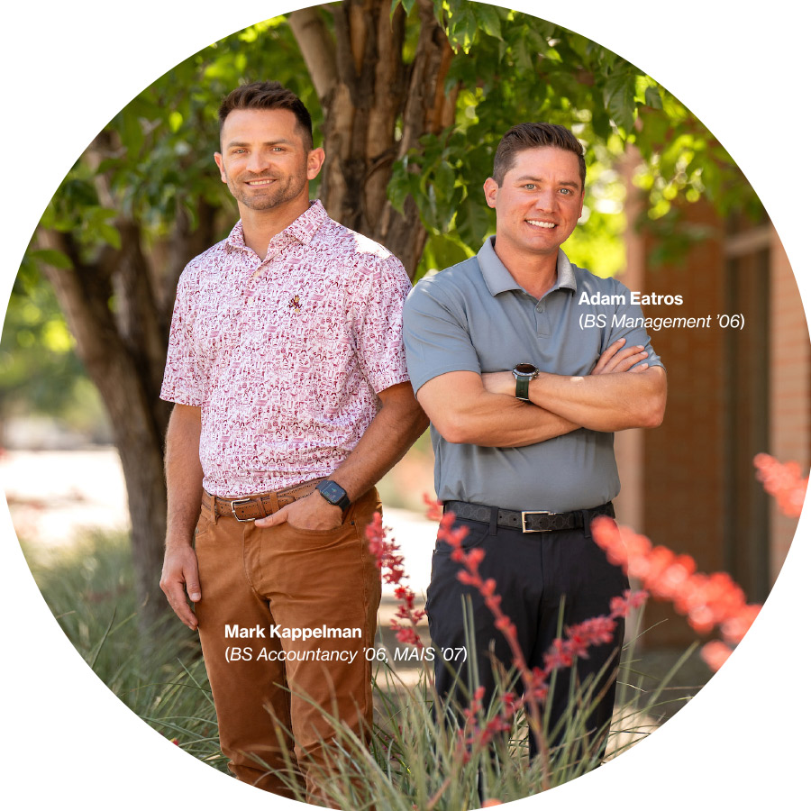 Mark Kappelman and Adam Eatros standing side by side smiling while wearing polo shirts, jeans, and belts