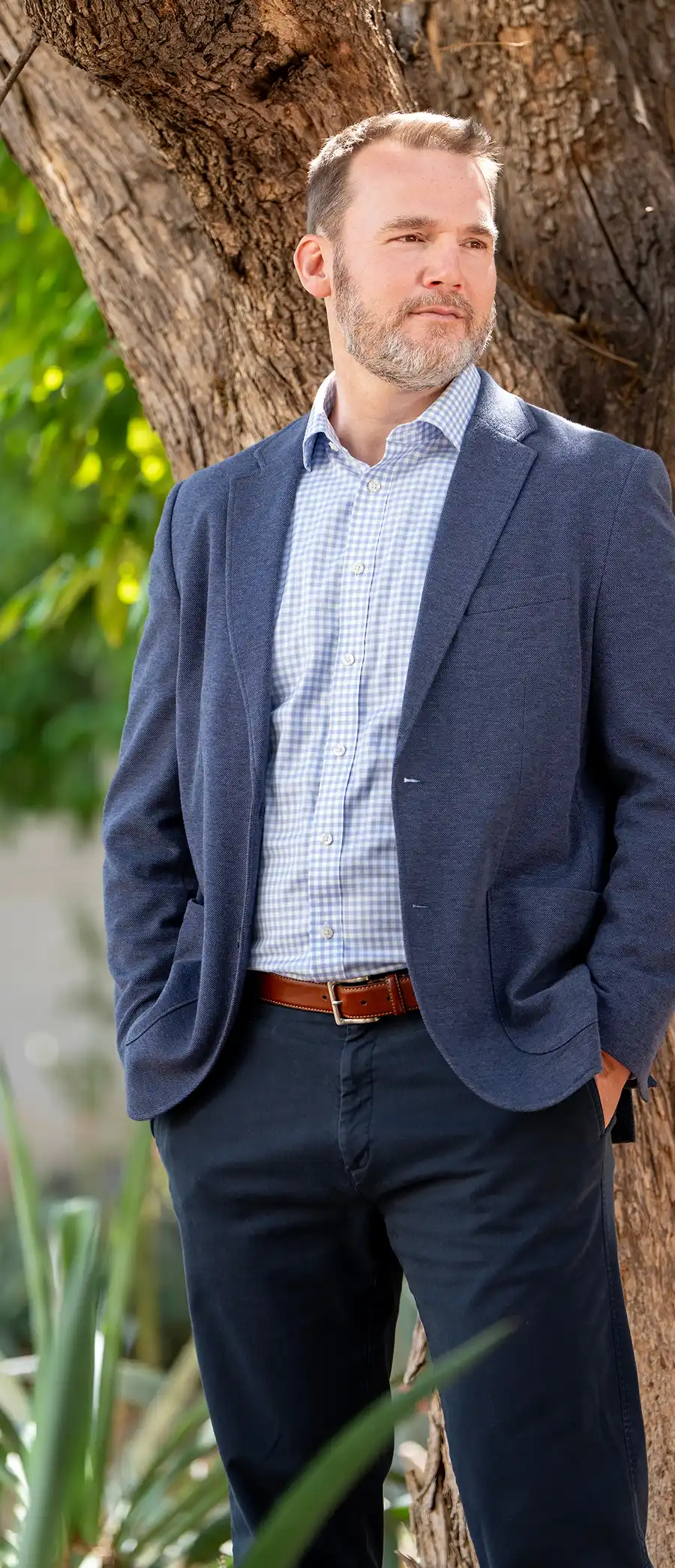 Robert Milligan in a blue blazer and checkered shirt standing outdoors